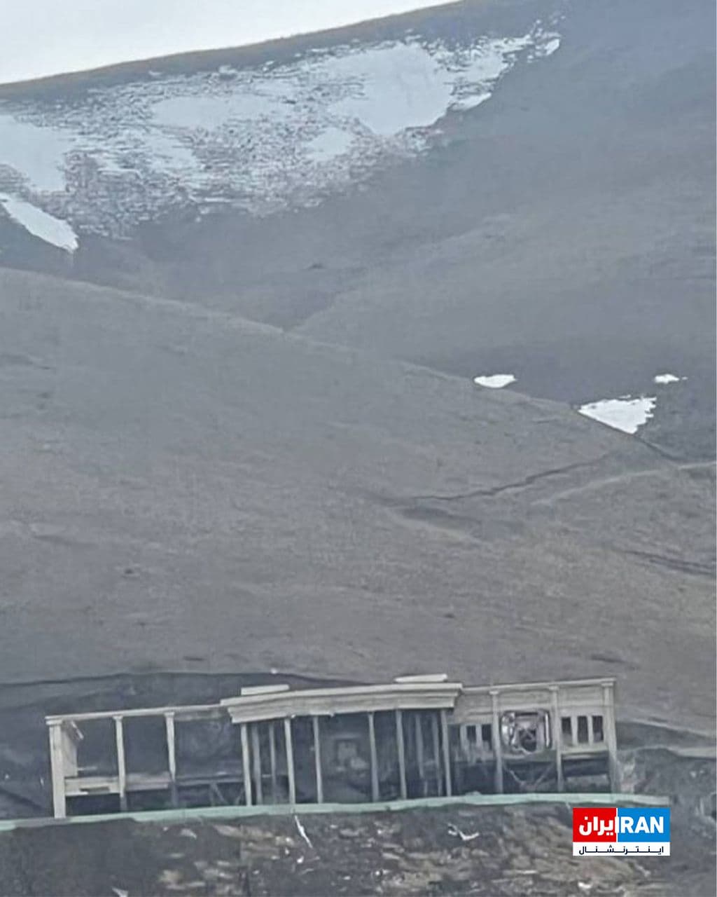 @ايران اينترنشنال: The image received by Iran International shows the destruction of an IRGC military base in the heights of Hamedan city near the "Martyrs of Diving" pool.