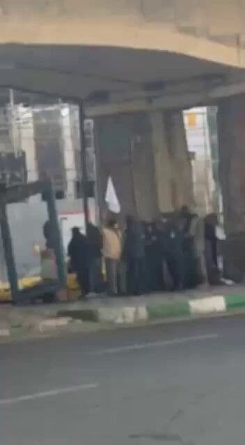 @Open Source Intel: Iranian opposition footage shows Basij members taking cover under a bridge in Tehran, fearing attacks. One is seen waving a white flag.