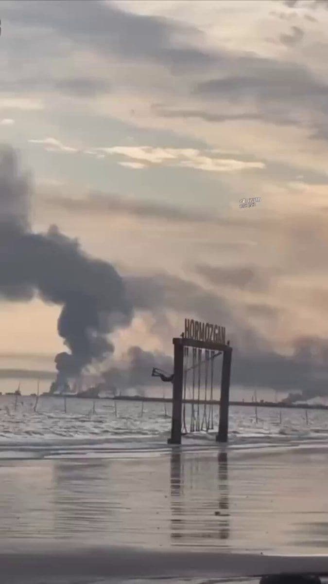 @Eli Afriat 🇮🇱: An Iranian girl swings on a beach in Bandar Abbas - and in the background smoke rises from a nearby naval base that was hit by airstrikes.🇮🇷💥