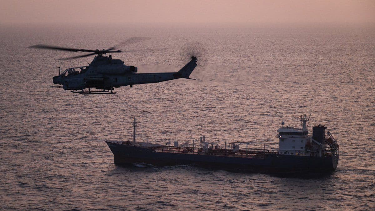@U.S. Central Command: A U.S. Marine Corps AH-1Z Viper attack helicopter patrols near a commercial vessel transiting regional waters as American forces enforce the maritime blockade against Iran. As of May 20, U.S. forces h