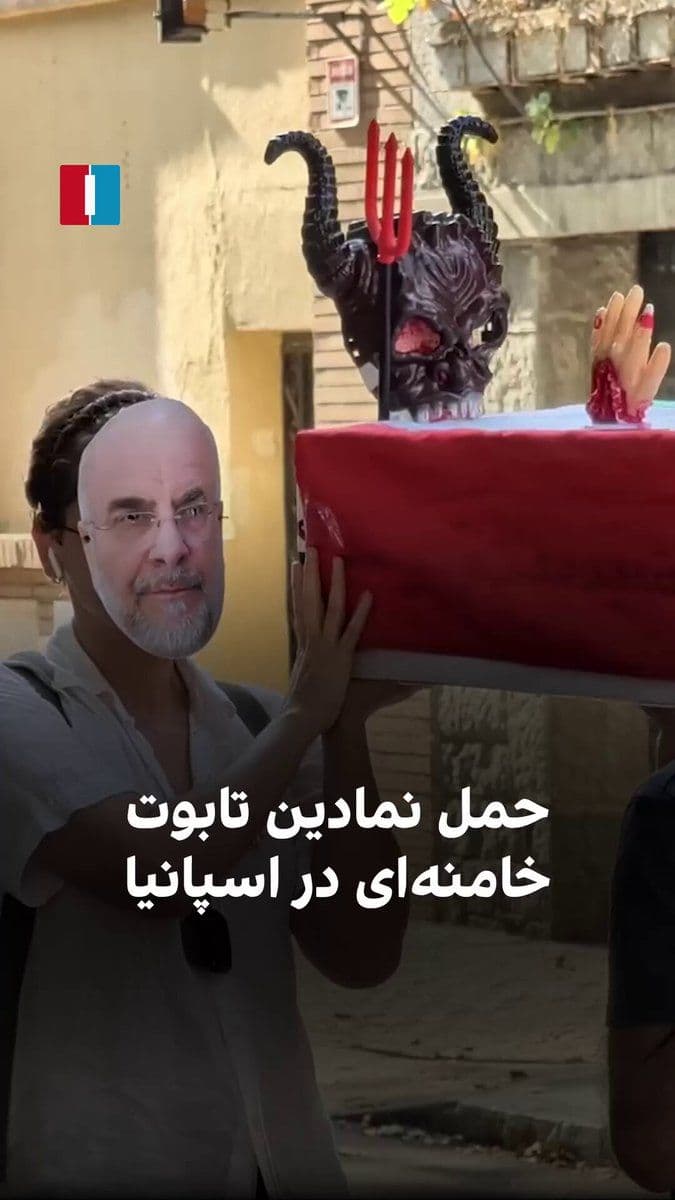 @ايران اينترنشنال: Iranians in Spain symbolically held a funeral ceremony for the coffin of Ali Khamenei on Thursday, during a gathering in front of the Islamic Republic's embassy in Madrid, wearing masks of Qalibaf, Pe